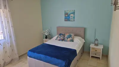 a small bedroom with a bed with a blue blanket at Apartamento Perto da Praia Albufeira in Albufeira