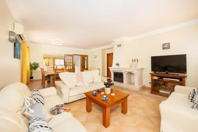 a living room with white furniture and a flat screen tv at Villa Santa Maria in Albufeira