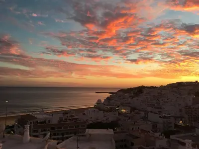 a sunset over a city with the ocean and buildings at Fantastic view over the sea in Albufeira