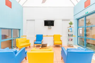 a group of chairs on a patio in front of a building at HI Faro – Pousada de Juventude in Faro