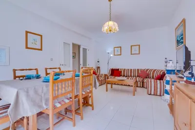 a living room with a table and a couch at Apartamento Farol com piscina e estacionamento in Vilamoura