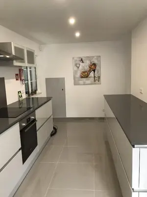 a kitchen with black countertops and a painting on the wall at 4 Bedroom Villa with Heated Pool close to Old Village in Vilamoura
