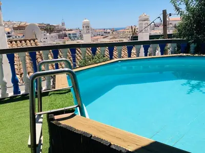 a large blue swimming pool on a balcony at Villa 2BDR with sea view, private pool in Albufeira