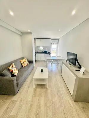 a living room with a couch and a tv and a table at Julio Apartment in Albufeira