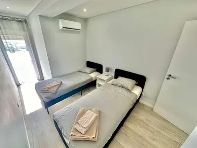 a room with two beds and a window at Julio Apartment in Albufeira