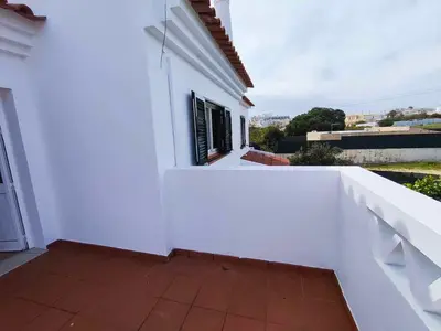 a white house with a white wall and a balcony at Albufeira INN - Mulatinho V3 in Olhos de Água