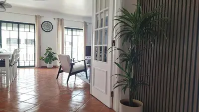 a living room with a potted plant next to a door at Apartamento Olhos do Mar in Olhos de Água
