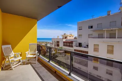 a balcony with two chairs and a view of the ocean at Parque Atlântico Modern Seaview Apartment with Pool and Tennis Court in Cavacos