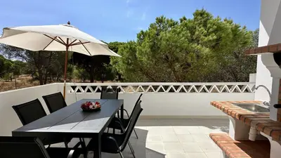 a table and chairs with an umbrella on a patio at Pine Cliffs by Check-in Portugal in Albufeira