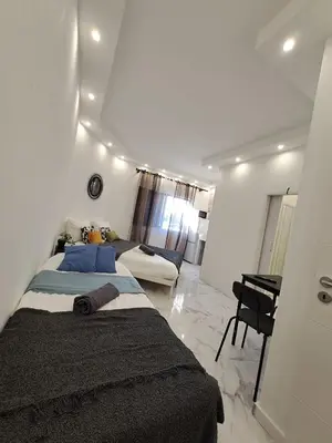 a white room with three beds and a table at Albufeira flats in Albufeira