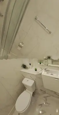 a white bathroom with a toilet and a sink at Albufeira flats in Albufeira