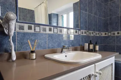 a bathroom with a sink and a hair dryer at Urban Bliss Guesthouse I in Faro
