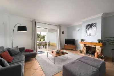 a living room with a couch and a fireplace at Stylish 2BR Ground Floor Apartment in Vila Sol, Direct Garden and Poolside Acces in Quarteira
