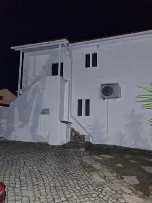a white building with an open door at night at Monteverde in Monte Negro