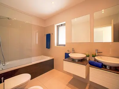 a bathroom with two sinks and a tub and a toilet at Apartment Pine Hills Diamante-12 by Interhome in Vilamoura
