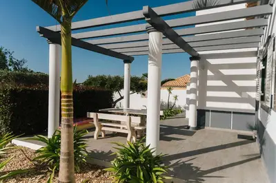 a white pergola with a picnic table on a patio at Villa Jorge by Ecovillas Albufeira in Galé