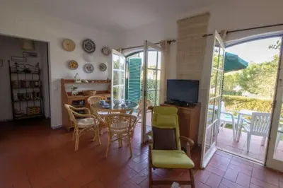 a living room with a table and chairs and a television at Old Village- 1A Village Gate in Quarteira