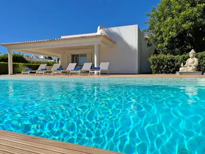 a villa with a swimming pool in front of a house at Stunning 4-Bedroom Villa With Pool - Perfect For Families in Albufeira