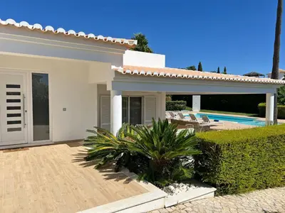 a white house with a patio and a swimming pool at Stunning 4-Bedroom Villa With Pool - Perfect For Families in Albufeira