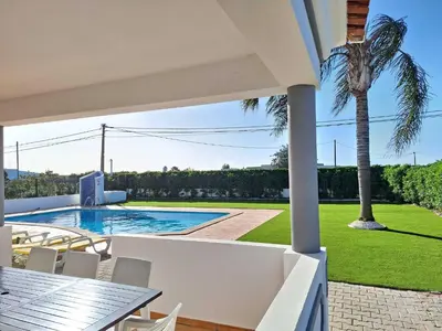 a villa with a palm tree and a swimming pool at Villa Ramos by Ecovillas Albufeira in Roja- Pé