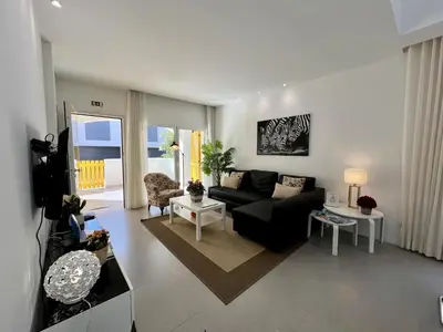 a living room with a black couch and a table at Vilamoura Club Villa 1 With Pool by Homing in Vilamoura