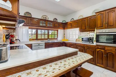 a kitchen with wooden cabinets and a counter top at Albufeira Villa El-Gharb private 4 Bedrooms in Albufeira