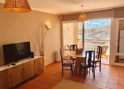 a living room with a table and chairs and a television at T1 Vista Marina de Vilamoura in Vilamoura