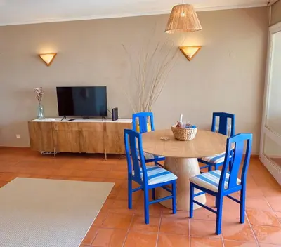 a dining room with a table and blue chairs at T1 Vista Marina de Vilamoura in Vilamoura
