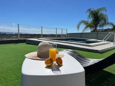 a table with a hat and a glass of orange juice at Ocean view by Charmes A in Albufeira