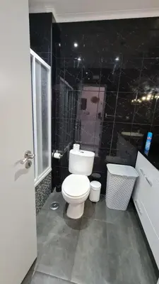 a bathroom with a white toilet and a shower at Apartamento T1 centro Albufeira in Albufeira
