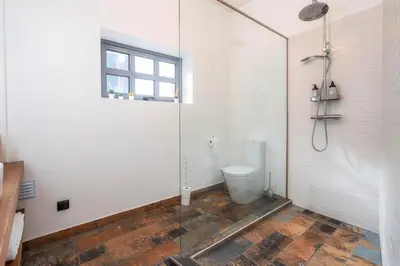 a bathroom with a toilet and a glass shower at Oakmoon House in Faro