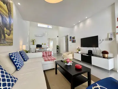 a living room with a white couch and a tv at Vilamoura Club Villa 2 With Pool by Homing in Vilamoura