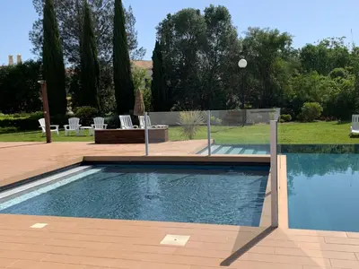 a swimming pool in a yard with chairs and trees at Vilamoura Club Villa 2 With Pool by Homing in Vilamoura