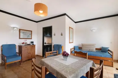 a living room with a table and a bed at T1 em Vilamoura - Parque Mourabel in Vilamoura
