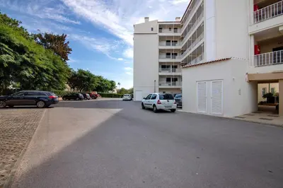 a street with cars parked next to a building at T1 em Vilamoura - Parque Mourabel in Vilamoura