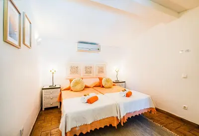 a bedroom with a bed with orange pillows on it at Villa Alice by Algarve Vacation in Albufeira