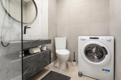 a bathroom with a toilet and a washing machine at BelChoro SeaLine in Albufeira