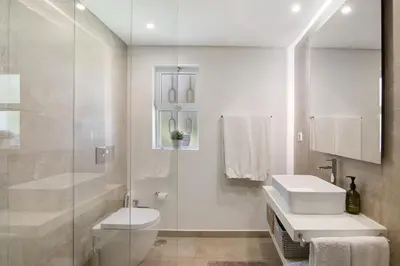 a white bathroom with a toilet and a sink at Casa Isabella in Vilamoura