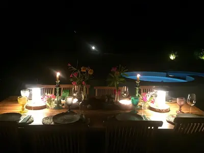 a table with candles and flowers on it at night at Casa Isabella in Vilamoura
