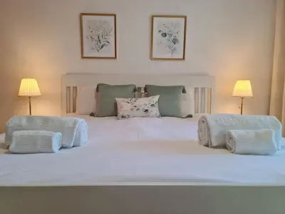 a large white bed with two lamps on it at Colina do Atlântico 203 in Albufeira