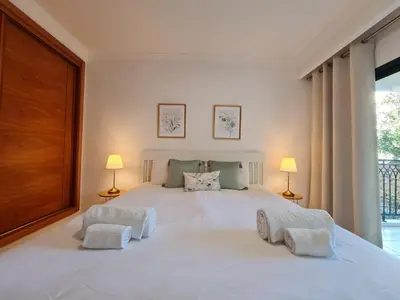 a bedroom with a large white bed with two lamps at Colina do Atlântico 203 in Albufeira