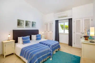 a bedroom with two beds with blue and white sheets at Villa Carlos in Loulé