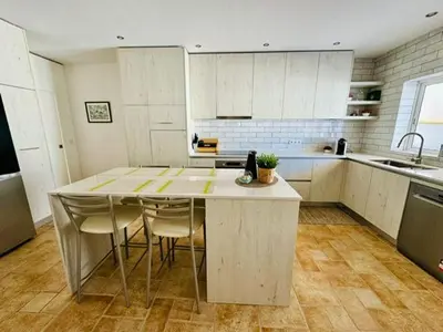 a kitchen with a table and some chairs in it at Casa Da Amélia in Albufeira