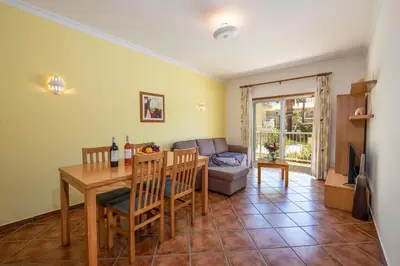 a living room with a table and a couch at Jardins Vale de Parra in Albufeira