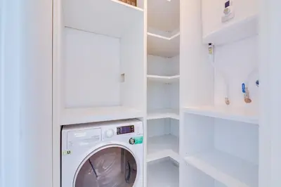 a white laundry room with a washer and dryer at Apartamento Gaivota frente-mar in Quarteira