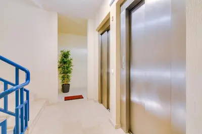 a hallway with a metal door and a potted plant at Apartamento Gaivota frente-mar in Quarteira