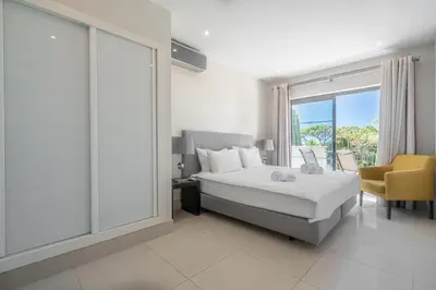 a bedroom with a bed and a large window at Vilamoura Pine Hills with Pool by Homing in Vilamoura