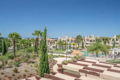 a view of a park with palm trees and buildings at Vilamoura Pine Hills with Pool by Homing in Vilamoura
