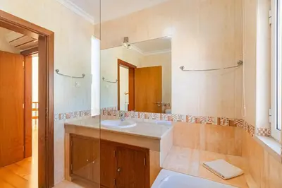 a bathroom with a sink and a mirror at Villa Coute Real in Quarteira