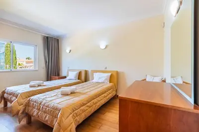 a bedroom with two beds and a large window at Villa Coute Real in Quarteira